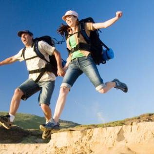 Tourists jumping over beach dune