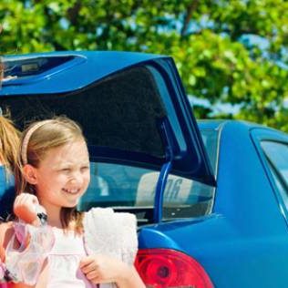 Family at beach with blue car