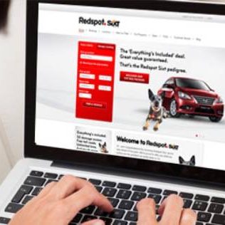 Redspot car rental website on laptop