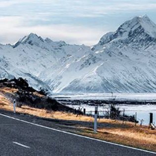 Road between snow covered mountains