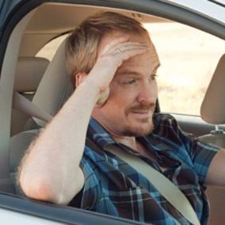 Dad driving rental vehicle stressed