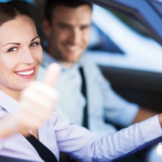 Woman giving thumbs up outside rental vehicle window