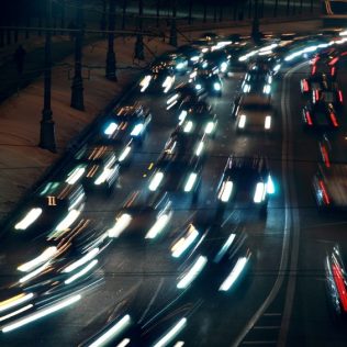 moving traffic at night with moving lights at winter; many cars